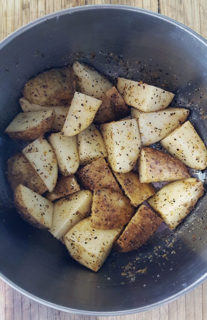 These Whole30 air fried potatoes get tossed in EVOO and Montreal steak seasoning before roasting. 