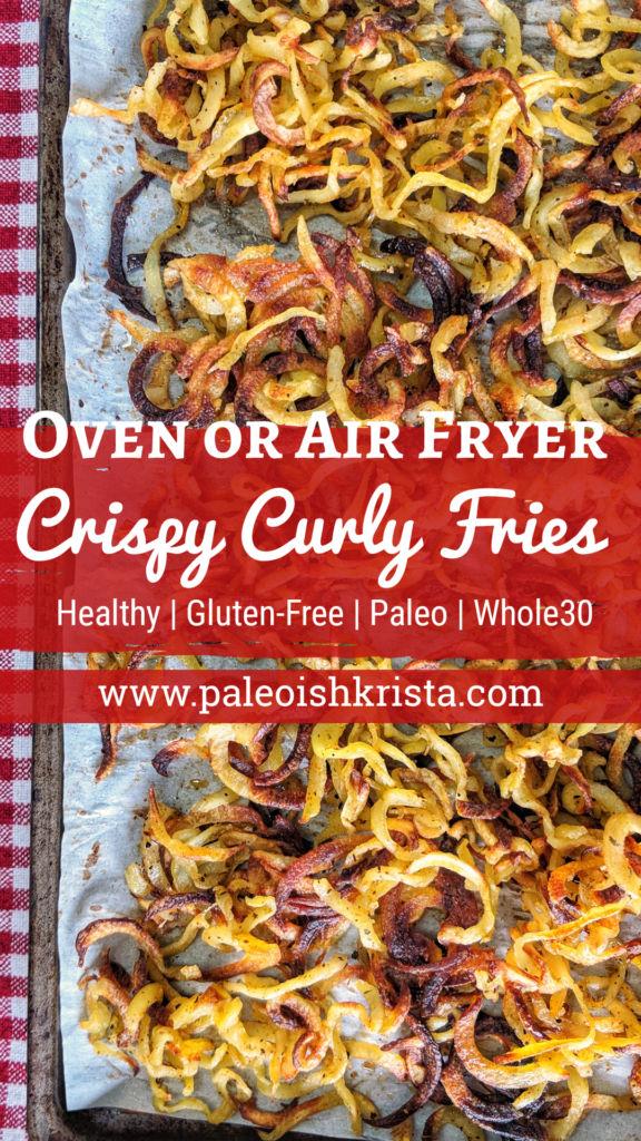 Set on top of a red checkered dish towel is a baking sheet lined in parchment paper with homemade crispy curly fries scattered about.