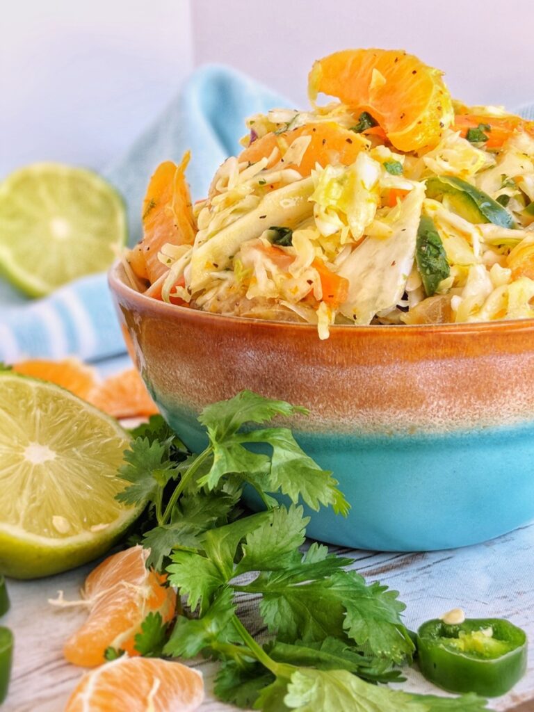 This colorful sweet and spicy coleslaw is made with shredded cabbage, mandarin orange pieces, sliced jalapenos, cilantro and a simple citrus vinaigrette.