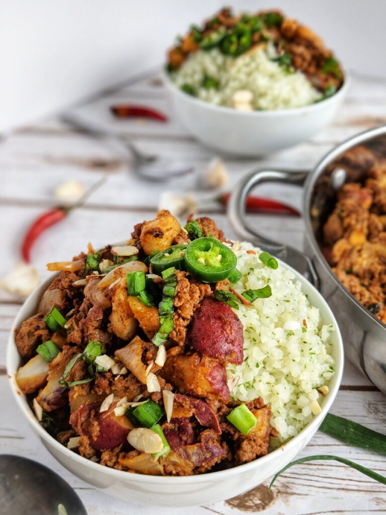 Served with fluffy cauliflower rice and topped with fresh green onions, jalapenos and sliced almonds -this Thai red curry ground beef and potatoes dish is absolutely delicious and super good for you!