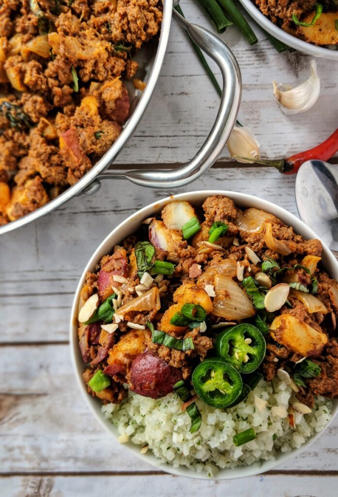 These Whole30 Thai Red Chili Beef Bowls are loaded with hearty cauliflower rice and a delicious red curry made with ground beef, potatoes and plenty of Thai-inspired flavors. This meal is great topped with green onions, sliced almonds and fresh jalapenos.
