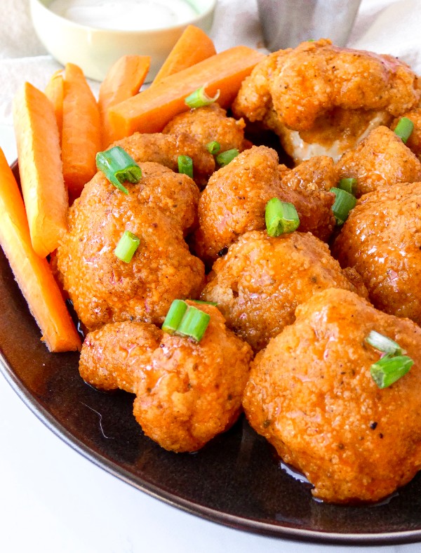 Plump cauliflower florets are breaded in almond flour, air fried or baked and tossed in spicy buffalo sauce.